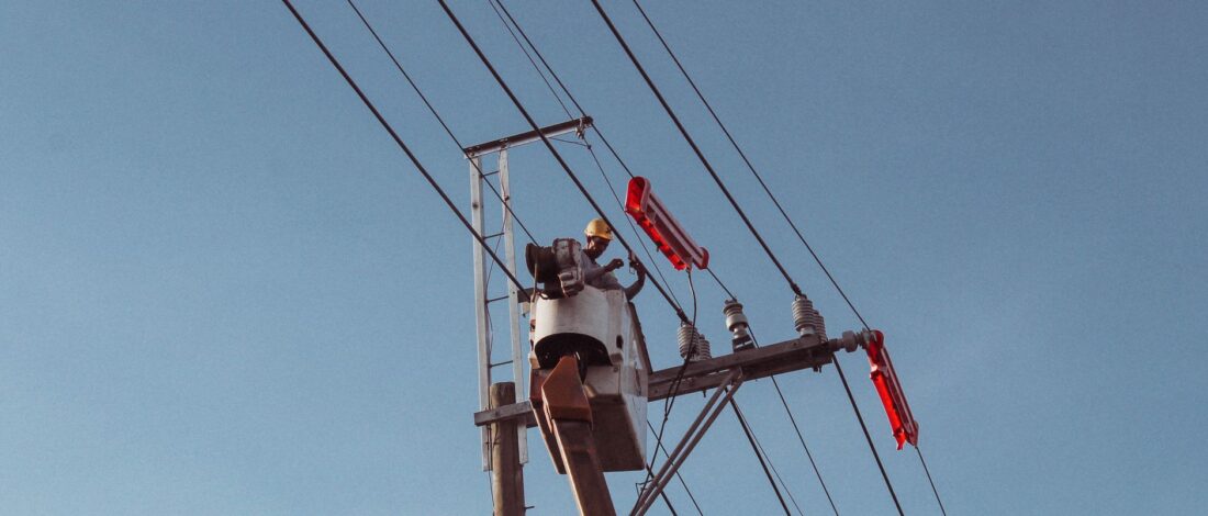 Engineer works on high power lines, ensuring electrical safety and maintenance.