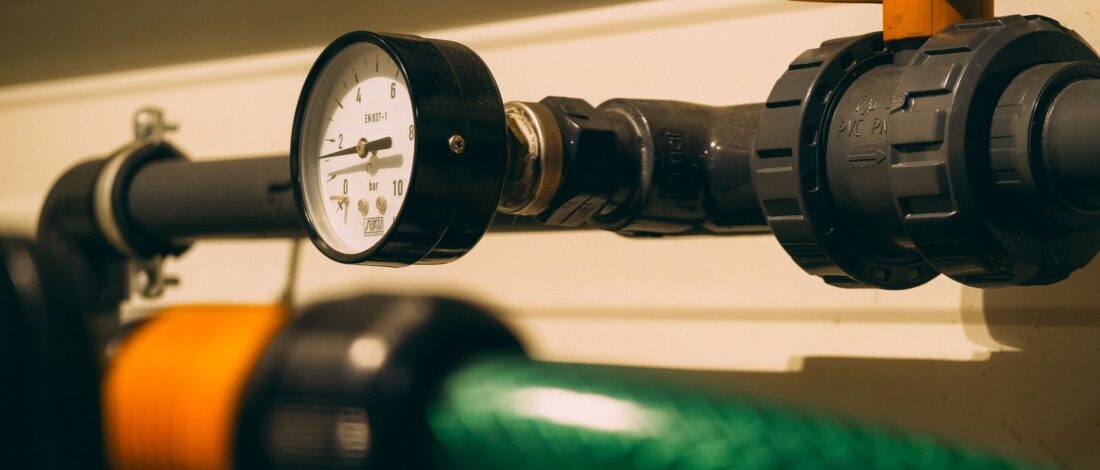 Close-up view of an industrial pressure gauge attached to piping. Ideal for engineering or industry visuals.