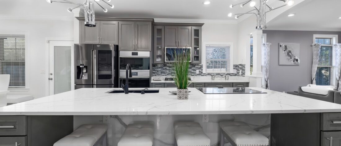 Spacious modern kitchen featuring marble countertops, contemporary design, and sleek appliances.